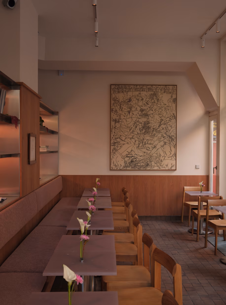 STROM cafe interior with wooden chairs, lilac tables and a large artwork