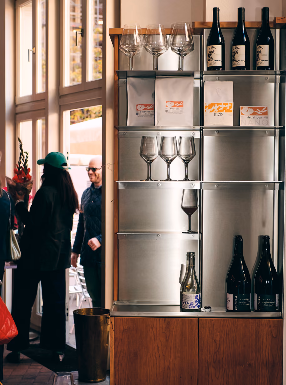 Steel shelving with wine bottles, glasses and coffee bags at STROM