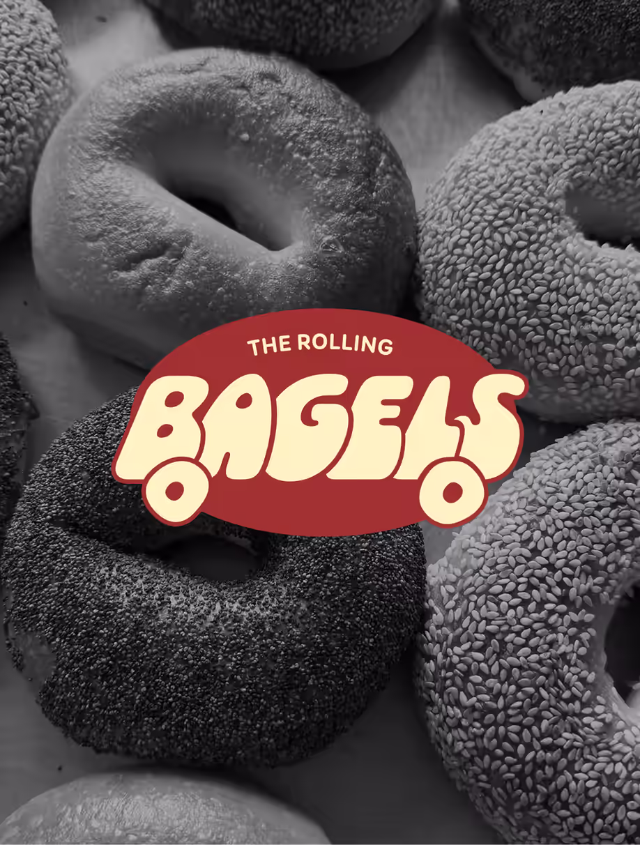 The Rolling Bagels logo over a black and white photo of sesame and poppy seed bagels
