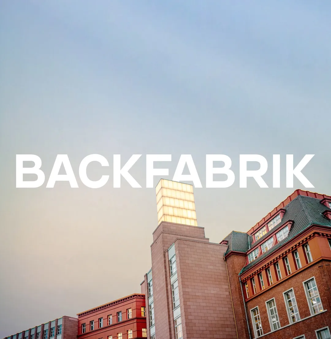 BACKFABRIK wordmark over the red-brick factory building