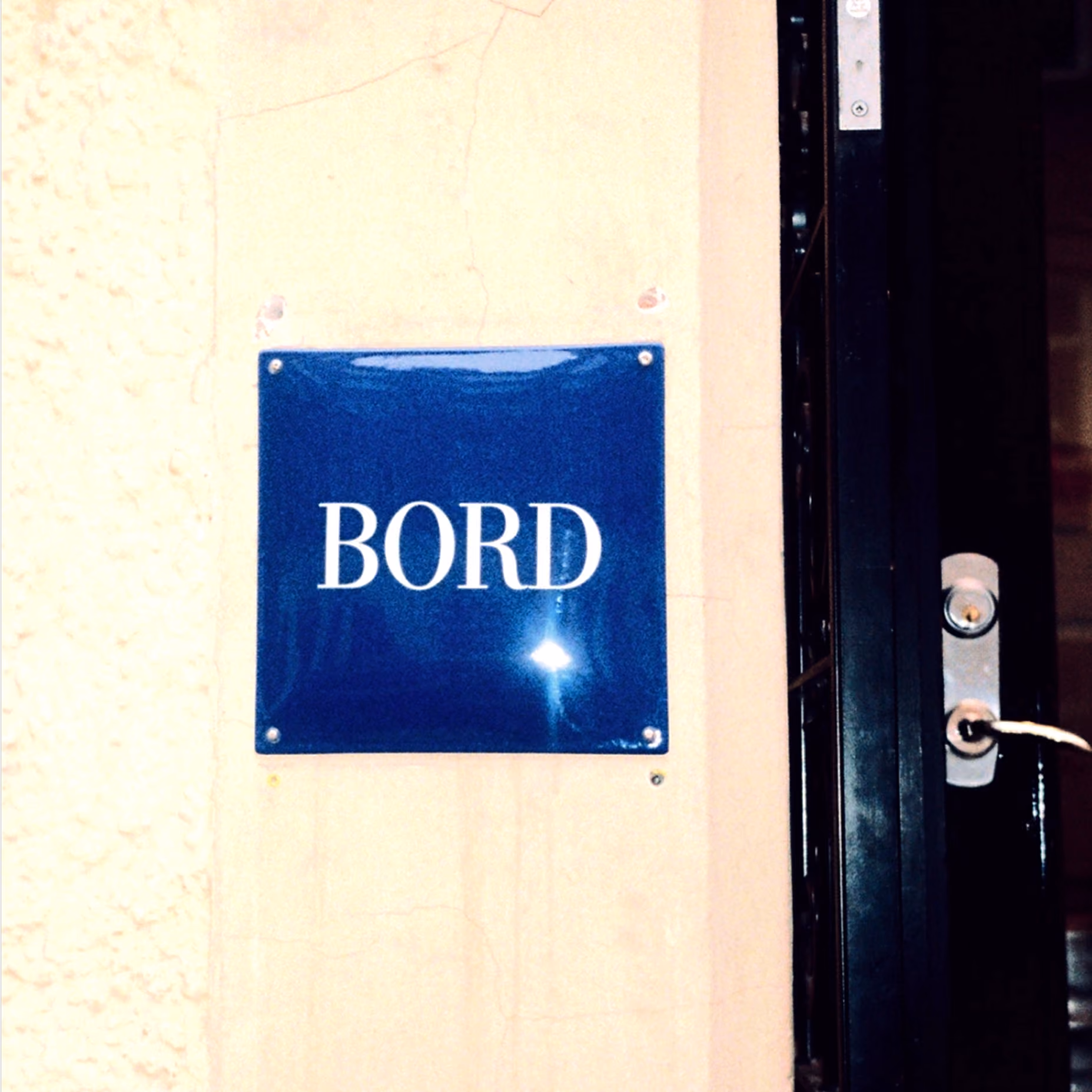 Blue enamel Bord sign mounted beside the restaurant's front door