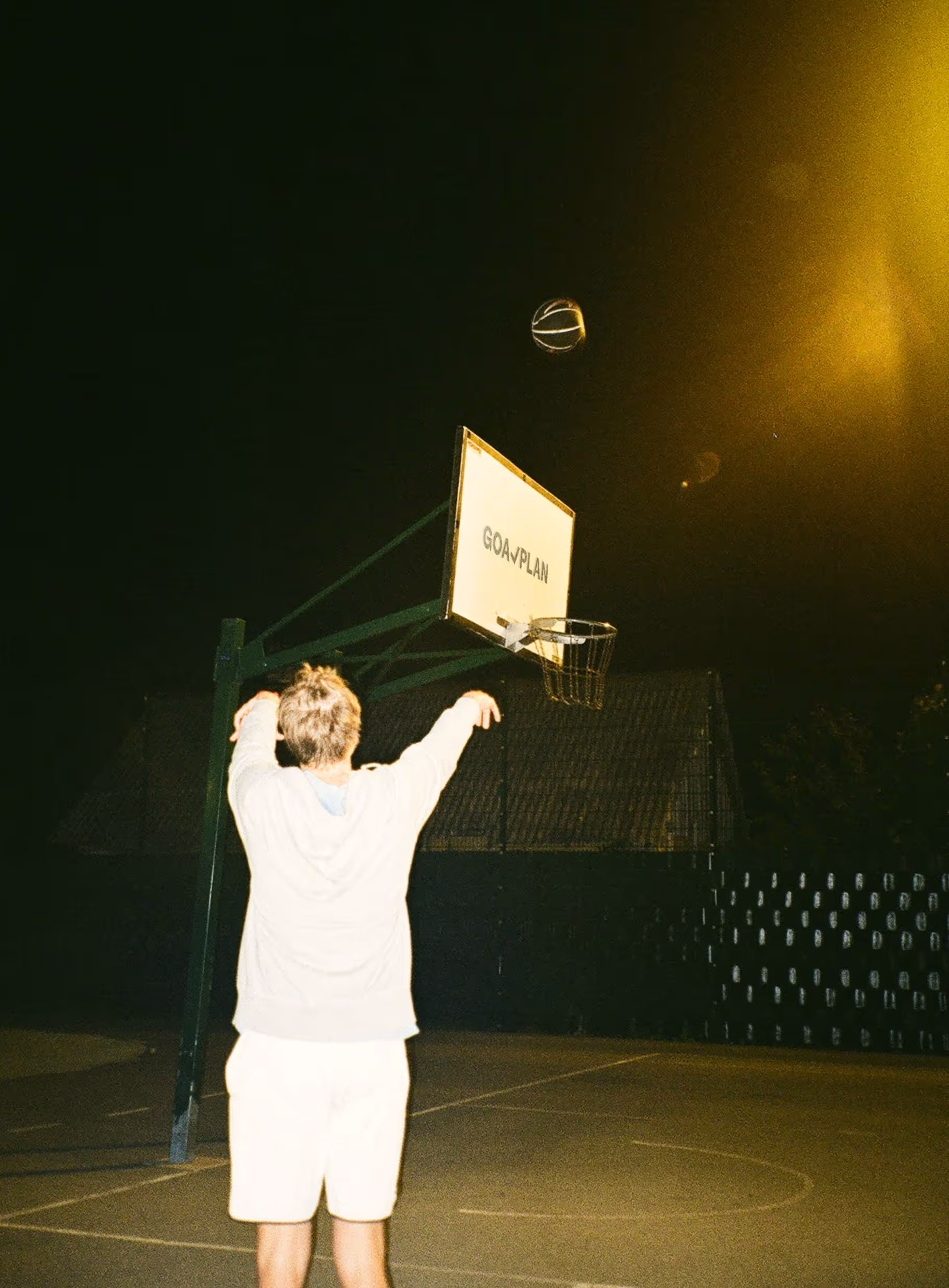 Image of a guy shooting hoops on a court with Goalplan branding