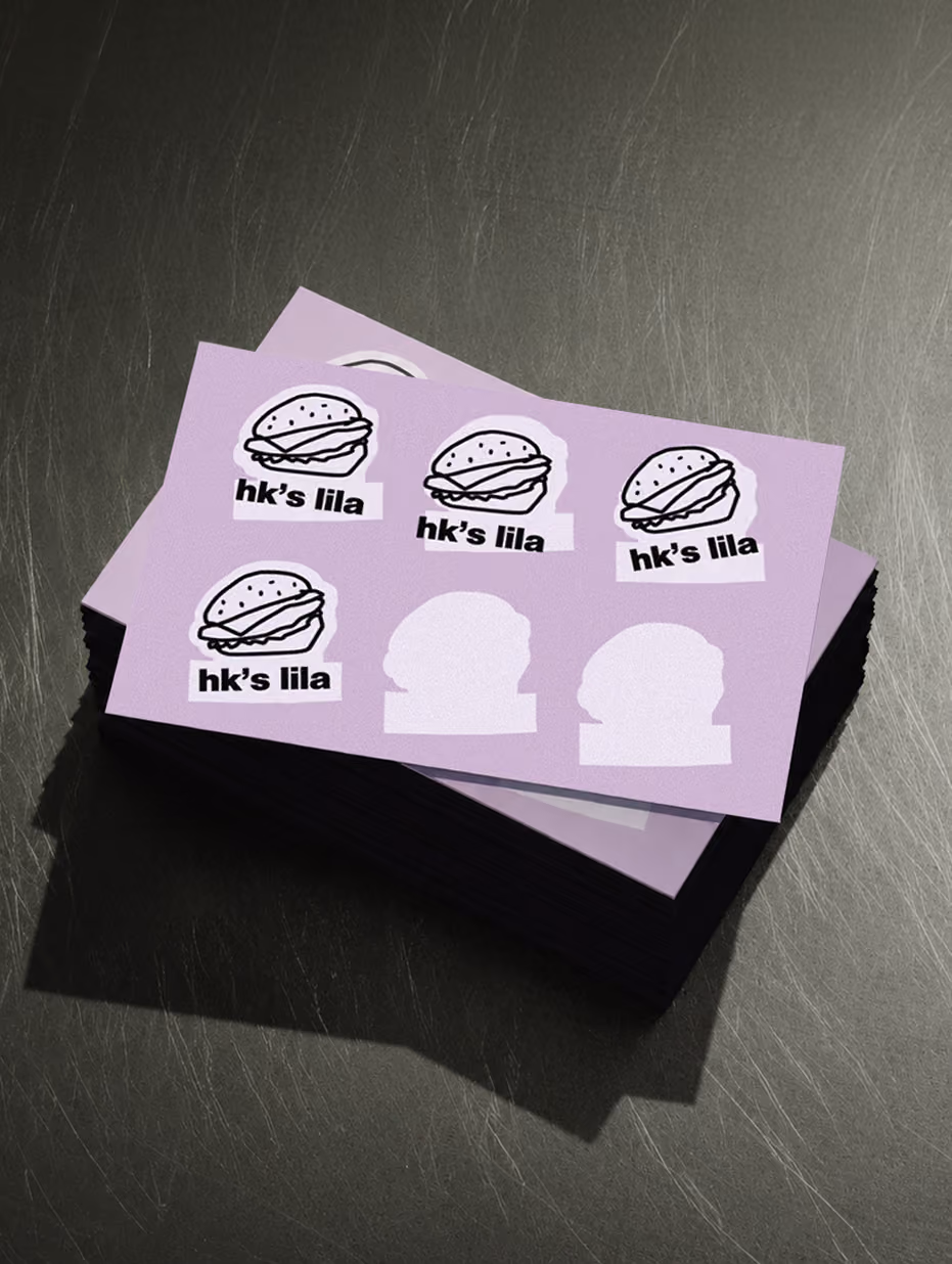 Stack of lilac HK's Lila sticker sheets with burger illustrations