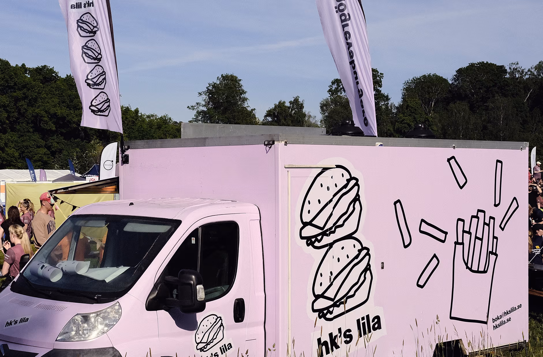 The lilac HK's Lila food truck decorated with hand-drawn burgers and fries