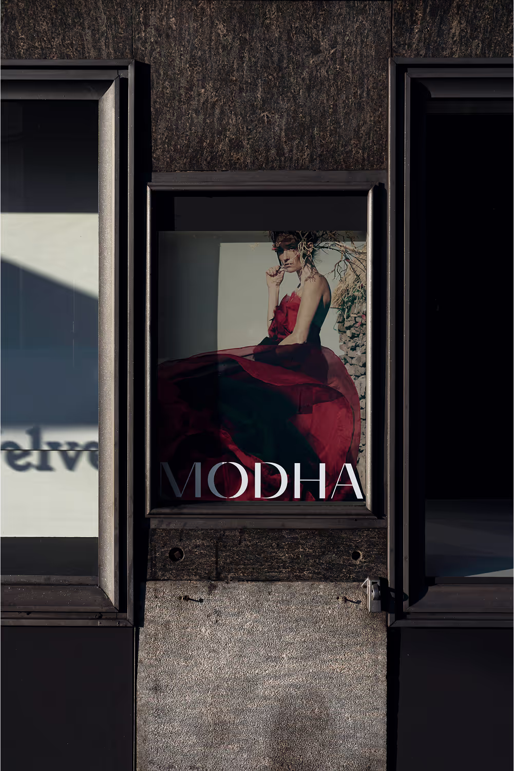 Modha poster with a model in a red gown in a window display