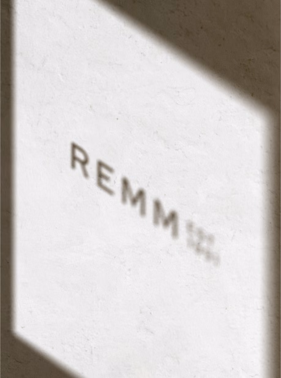 REMM logotype on a sunlit white wall