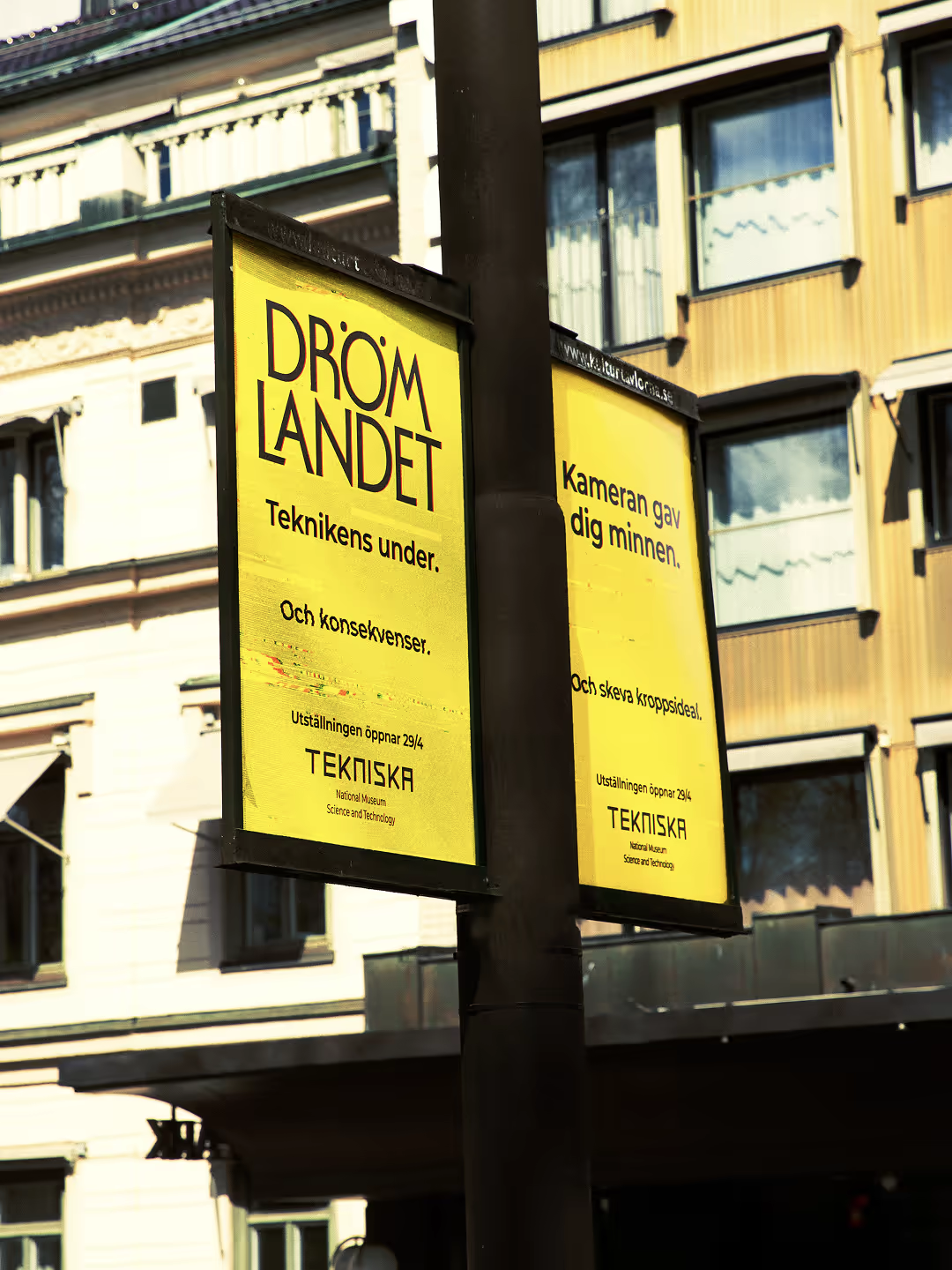 Two Drömlandet culture boards mounted on a lamp post in central Stockholm
