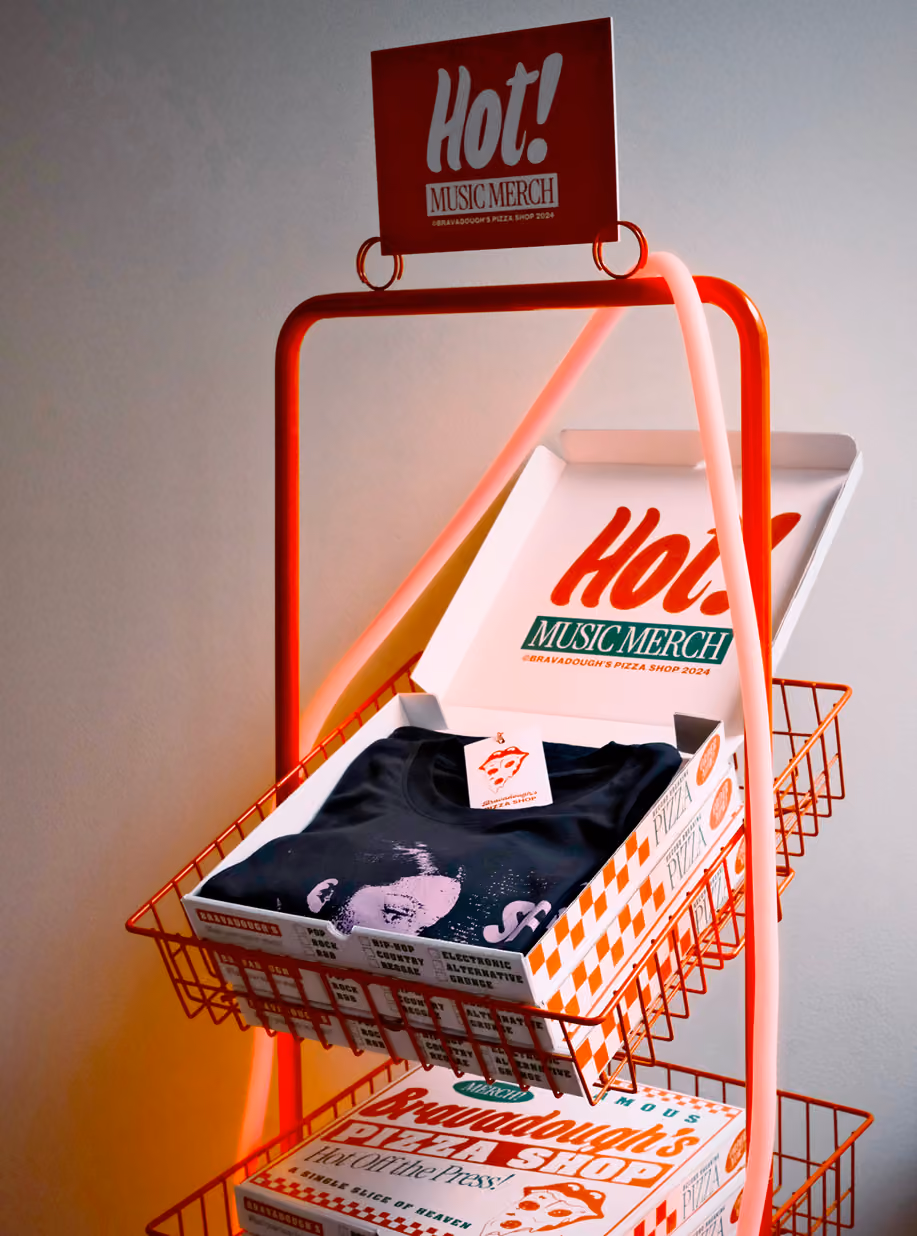 Wire rack displaying a Hot! Music Merch box with a band T-shirt
